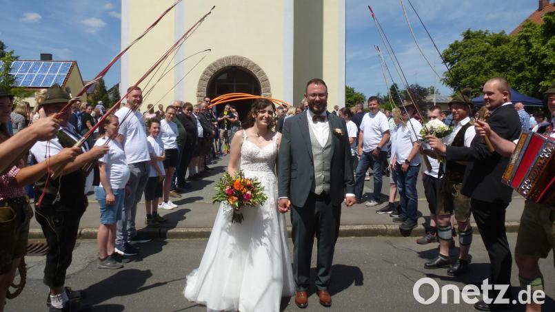 Strahlend ins Eheglück: Julian und Lena Kraus beim Durchschreiten des Ehrenspaliers. Bild: bk