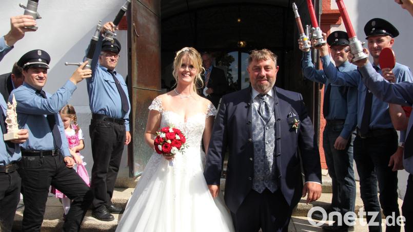 Simone und Karl Kohl beim Verlassen der Stadtpfarrkirche. Dort erwartete die Feuerwehr Matzersreuth die frisch Vermählten im Ehrenspalier. Bild: kro
