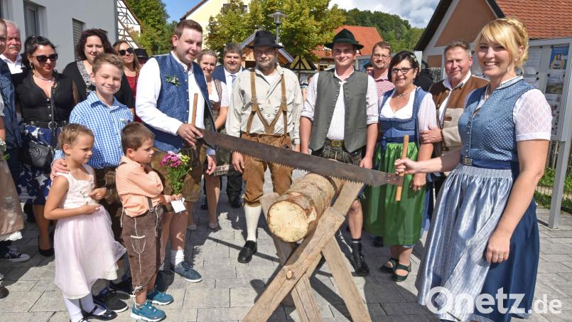 Mit Baumstamm und Säge warten die Mitarbeiter von Holzbau Strobel, als ihr Chef Leander Strobel und seine Frau Ramona nach der standesamtlichen Trauung das Rathaus in Illschwang verlassen. Bild: no