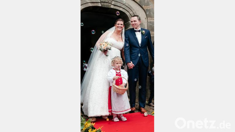 Claudia und Christian Lindner mit Blumenkind Sarah beim Verlassen der Kalvarienbergkapelle: Nach der Trauung warten viele Gratulanten auf das Brautpaar und empfangen es unter anderem mit Seifenblasen, die sinnbildlich für den Wunsch nach Erfüllung der Träume und Wünsche der &quot;Hochzeiter&quot; stehen. Bild: lep