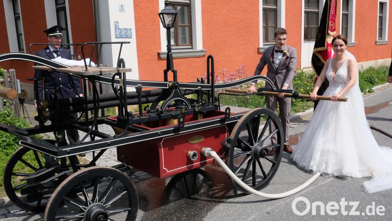 Nach der Hochzeitsmesse in der Johannes-Kirche Oberbibrach wartete auf die Jungvermählten Julia und Manuel Bauer eine Übung am historischen Löschwagen der Ortsfeuerwehr Oberbibrach Bild: do