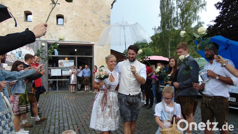 Nach der standesamtlichen Trauung gehen Celine und Daniel Fenk mit ihrer Hündin Fay durch das Spalier, das Freunde und Kollegen vor dem Steinstadel gebildet haben. Bild: fnk