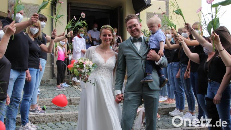 Julia und Johannes Malzer mit ihrem gemeinsamen Sohn Toni beim Verlassen der Hohenthaner Pfarrkirche. Sie gehen hier durch den Reigen des Ehrenspaliers der Turngemeinschaft Tirschenreuth. Bild: kro