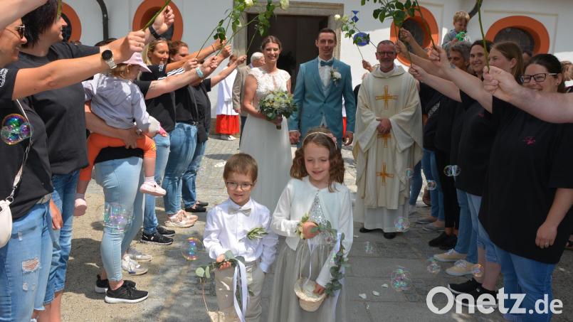 Kirchlich geheiratet haben am Samstag in der Dreifaltigkeitskirche Kappl die Mitterteicherin Christina Mayer und der Münchenreuther Tobias Grillmeier. Mit dabei waren auch die beiden Brautkinder Jonas und Lara. Ebenfalls im Bild Pfarrer Dr. Thomas Vogl sowie die Damen des Mitterteicher Gaudiwurms beim Ehrenspalier. Bild: jr