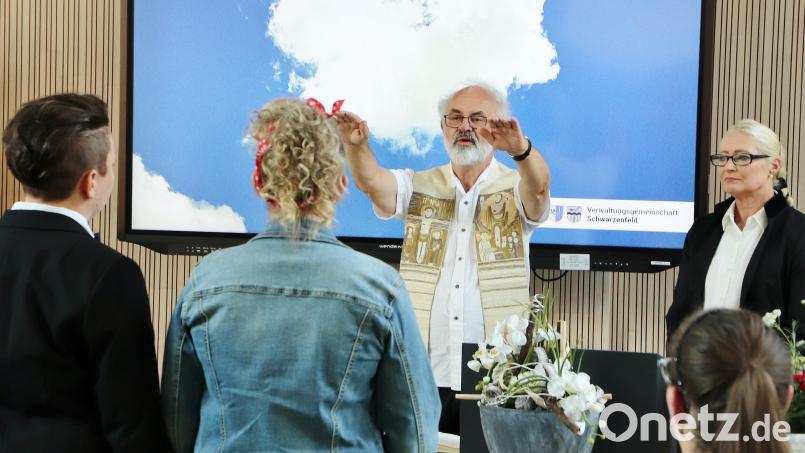 Pfarrer Heinrich Rosner spricht nach der standesamtlichen Trauung durch die Zweite Bürgermeisterin Gabi Wittleben (rechts) im Sitzungssaal des Rathauses den Segen über das gleichgeschlechtliche Hochzeitspaar. Bild: Thomas Dobler