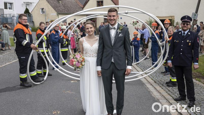 Andreas und Carina Luber schreiten durchs Rosen- und Schlauchspalier ins Eheglück. Bild: bk