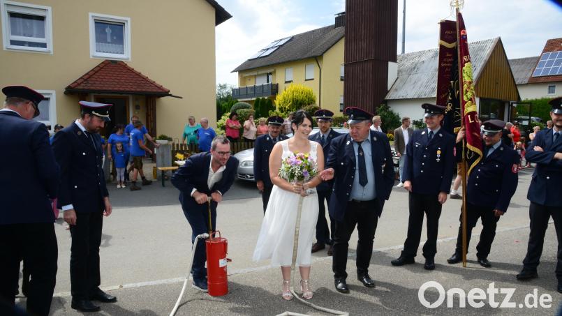 Da kann sich Bräutigam Daniel Balk noch so bemühen, die museumsreife Pumpe transportiert das Wasser nicht zur Spritze, die Braut Anna Balk einsetzbereit in ihren Händen hält. Bild: bey