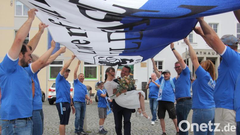 Auf Händen trug Markus Schwägerl seine Frau Anja unter dem Löwen-Banner hindurch, das die Löwenfreunde hielten. Ein Ehrenspalier bildeten außerdem die Alte-Herren-Fußballer der Sportfreunde Kondrau. Bild: kro