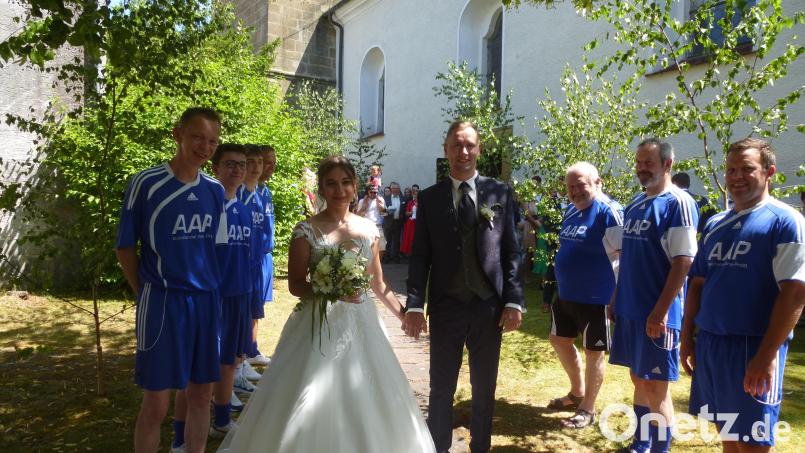 Spalier unter schattenspendenden Linden stehen die Fußballer für Florian und Kristin. FC-Vorsitzender Andreas Malzer gratuliert anschließend und wünscht alles Gute für die gemeinsame Zukunft der Frischvermählten. Bild: bk