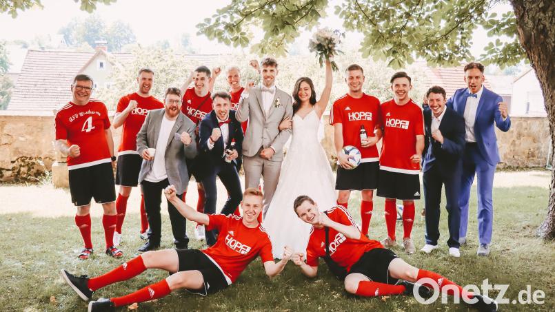 Das Brautpaar Sarah und Florian Burger zusammen mit den ASV-Fußballern nach der Trauung in Plößberg. Bild: Lena Härtl/exb