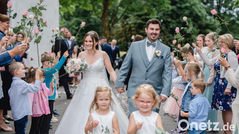 Sandrina und Julian Reil schreiten nach der Trauung durch ein Blumenspalier. Bild: Jennifer und Thorsten Photography