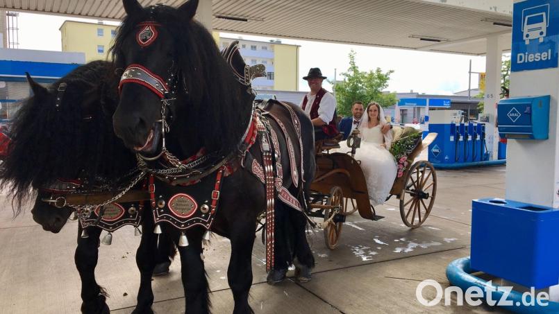 Das Brautpaar mit den beiden Dieselrössern in der Aral-Tankstelle. Bild: upl