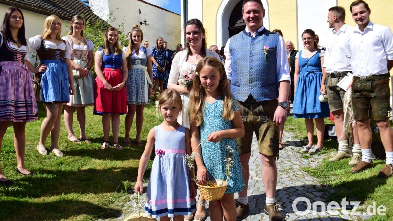 Andrea und Robert Meier schreiten durch ein Hochzeitsspalier, das von Kirwapaaren aus Illschwang und Ritzenfeld sowie von Mitgliedern des CSU-Ortsverbands Illschwang gebildet wird. Bild: no