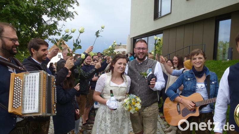 Julian Kraus und Lena Schieder strahlen nach ihrer standesamtlichen Hochzeit beim Durchschreiten des Ehrenspaliers vor Freude. Bild: bk