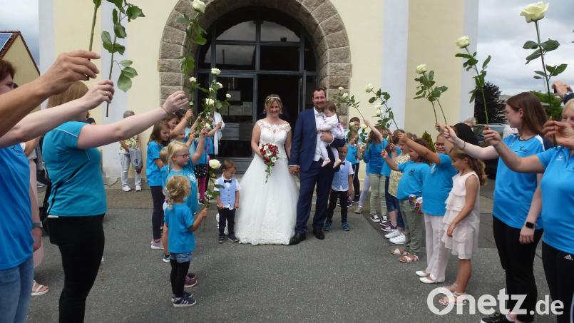 Mit ihrem zehn Monate alten Töchterchen Annalena durchschreiten Stefan und Martina Götz das bis in die Kirchstraße hinein reichende Spalier. Bild: bk