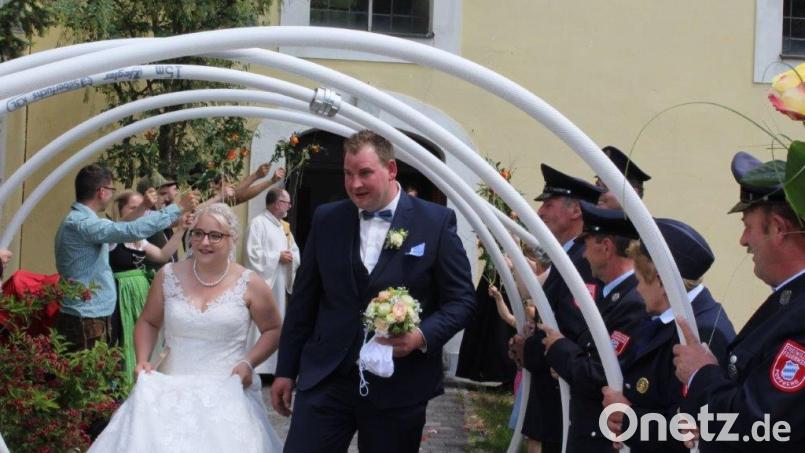 Yvonne und Roland Schmid schreiten durch das Spalier, hinten links an der Kirchentür Peter Bublitz, Diakon und Vater der Braut. Bild: sis