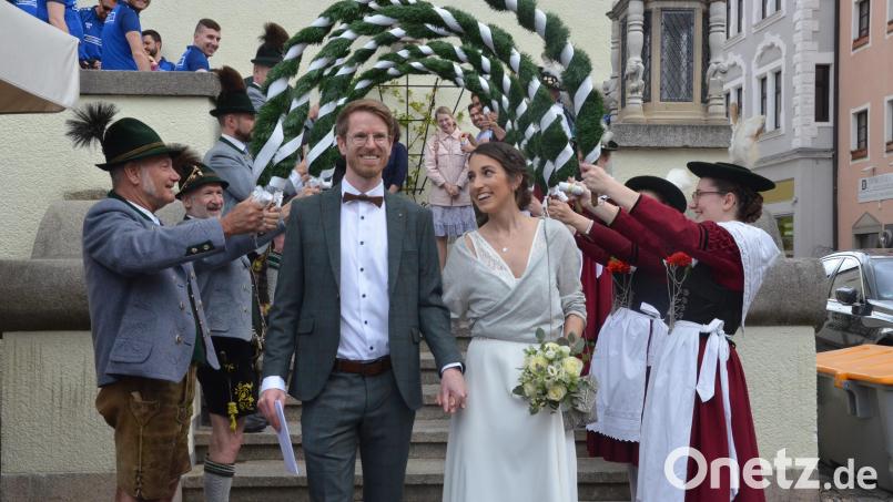 Martin und Stefanie Jess passieren das Spalier der Trachtengruppe Almrausch. Bild: Kunz