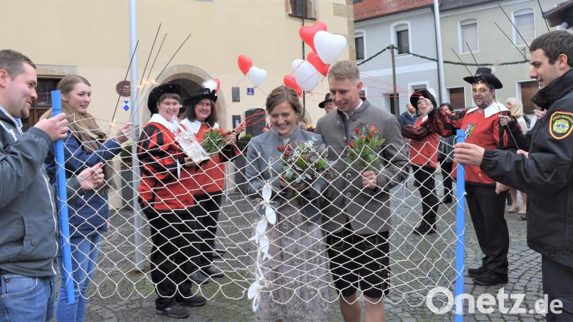 Isabelle Schmidt und Marcel Moeller geben sich im Grafenwöhrer Rathaus ihr Ja-Wort. Der Spielmannszug Grafenwöhr und ein Teil des Freundeskreises, die ein Netz spannen, gratulieren dem Paar. Bild: rgr
