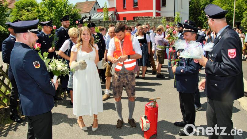 Das Brautpaar Barbara und Uwe absolviert bei der Feuerwehr Röckenricht die letzte Prüfung nach einem langen Hochzeitsspalier. Bild: ker