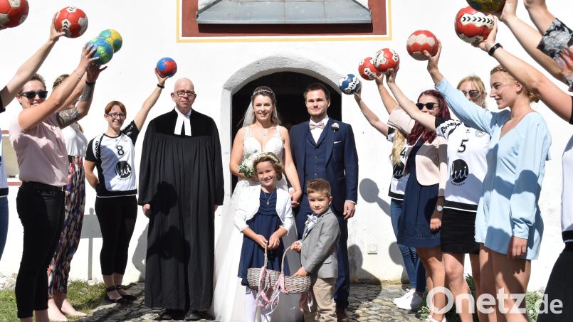 Das frisch vermählte Paar schreitet, beobachtet von Pfarrer Thomas Schertel, durch das Spalier der Damenmannschaft des Handballclubs Sulzbach-Rosenberg. Bild: no