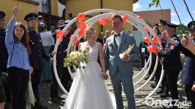 Nach der kirchlichen Trauung durfte das Braurpaar, von Freunden begleitet, durch viele große, mit roten Herzchen verzierte "Ringe" schreiten. Bild:  ubb