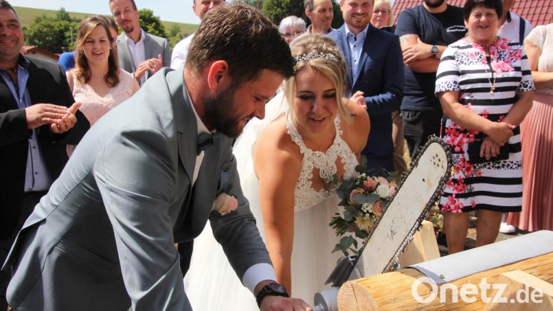 Mit vereinten Kräften sägten Bianca und Stefan Kraus mit einer Handkettensäge der Marke Eigenbau. Das Brautpaar heiratete in der Pfarrkirche St. Johannes in Großkonreuth. Bild: kro