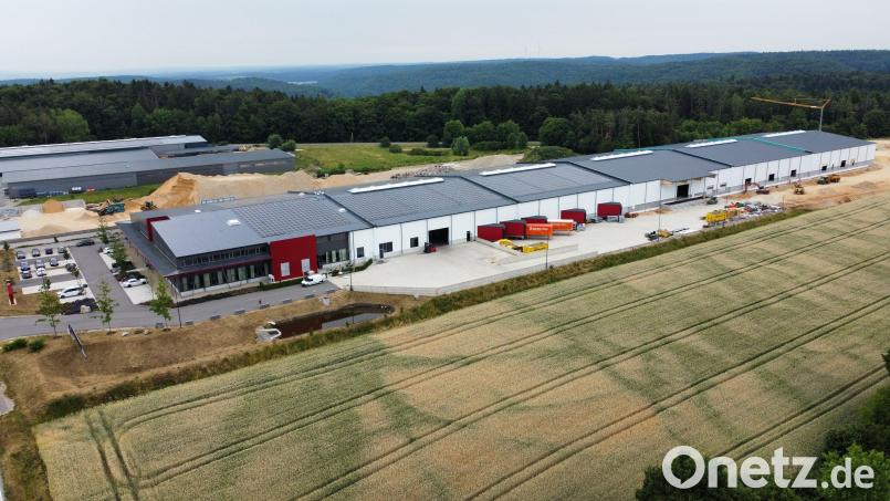An das Bürogebäude (mit Schulungsräumen und Kantine) vorne schließen sich auf 300 Meter Länge fünf Technik- und Lagerhallen an. Die hintersten beiden sind derzeit an externe Firmen vermietet. Durch die roten Ein- und Ausladeboxen an der Seite der Hallen haben sich die Beladezeiten für Lkw drastisch verkürzt. Bild: ATH Heinl/exb