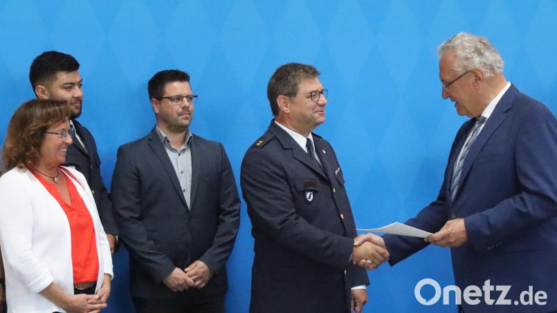 Innenminister Joachim Herrmann (rechts) übergibt die Ruhestandsurkunde an Polizeioberrat Oliver Mignon. Mit im Bild von links: Ulrike, Mignon, Neffe Jason Mignon und Sohn Benjamin Mignon. Bild: mfh
