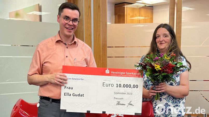 Ella Gudat (rechts) freut sich über 10.000,00 Euro aus dem PS Sparen &amp; Gewinnen. Filialdirektor Michael Schelkshorn (links) überreichte Blumen und einen symbolischen Scheck. Bild: Sparkasse/exb