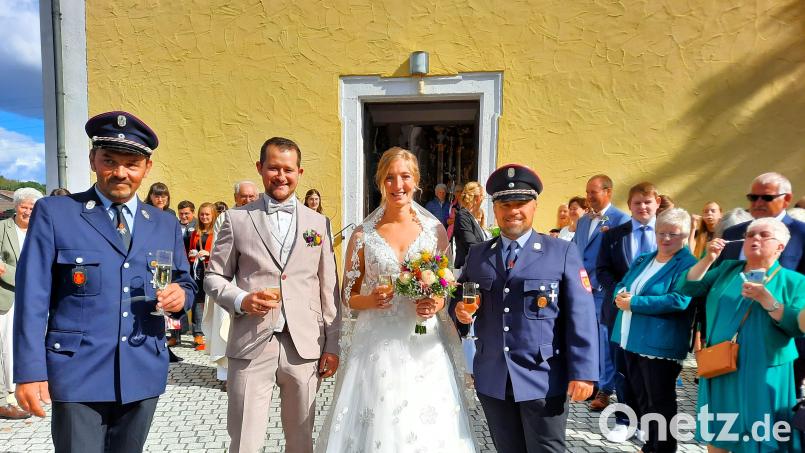 Frisch vermählt nehmen Thomas und Denise die Glückwünsche zu ihrer Hochzeit entgegen. Josef Meißner und Christian Wirth gratulieren für die Feuerwehr Pirk. Bild: kki