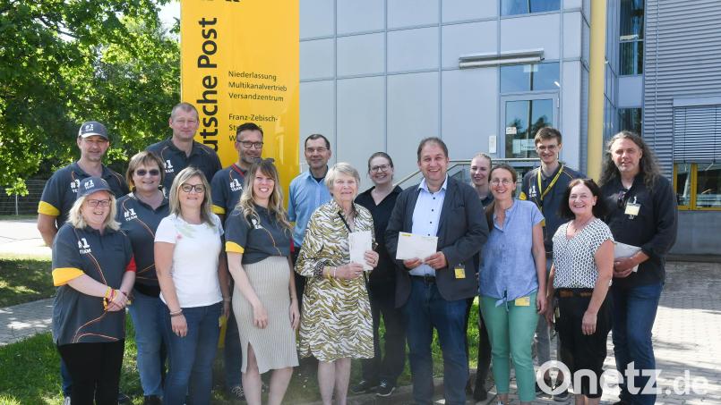 Vertreter des DHL-Post-Versandzentrums überreichen je 1500 Euro an Renate Freuding-Spintler (vorne, Vierte von rechts), Holger Hassel (rechts daneben) und Matthias Rössle (rechts). Bild: Gabi Schönberger