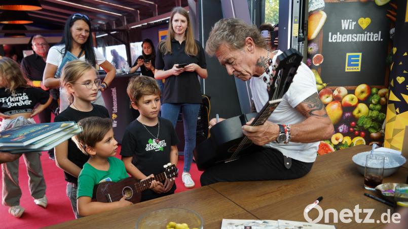 Helena, Lorenz und Kilian lassen sich ihre Gitarren und eine Ukulele von Peter Maffay signieren. Bild: kaz