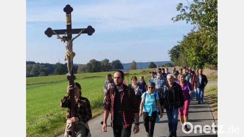 Jonas Hofmann und Katja Schönberger führen die Wallfahrer an, die sich von Schirmitz aus auf zum Fahrenberg machen. Abwechselnd tragen sie das Pilgerkreuz. Bild: Wulfänger/exb