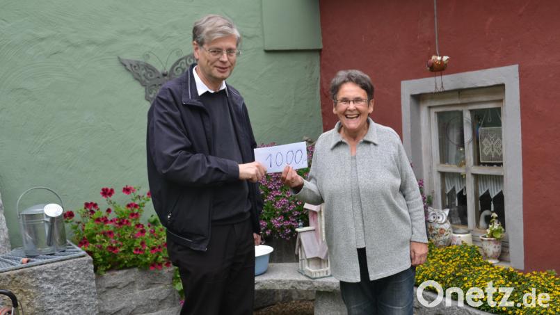 Christa Wildenauer übergibt Pfarrer Norbert Götz eine Spende von 1000 Euro. Bild: dob