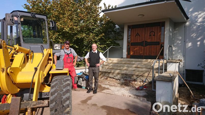 Pfarrer Heinrich Arweck und ein Bauarbeiter vor der Kirchentreppe der Auferstehungskirche, die renoviert werden muss und in Zukunft Namen von Ambergern zieren wird. Bild: wku