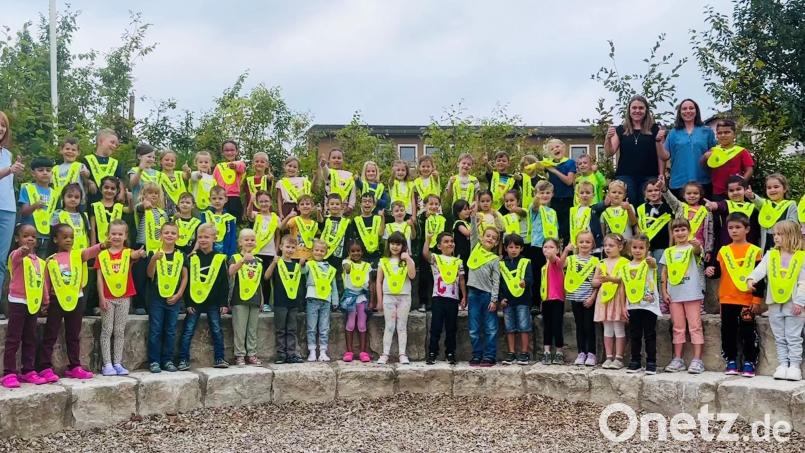 In Grafenwöhr „kleidet“ Andreas Bscherer (links) von der Gebietsverkehrswacht im Beisein der Klassenlehrerinnen 64 Erstklässler mit Sicherheitsüberwürfen ein. Bild: Bscherer/exb
