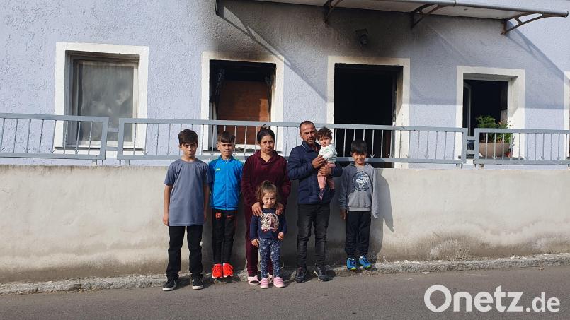 Familie Bilasini , Vater Wisam, Ehefrau Sahira, die fünf Kinder Hedel, Vidl, Aydil, Elina und die acht Monate alte Alina, steht vor dem rußgeschwärzten Eingang ihres mühevoll restaurierten Eigenheims, das durch den Band jetzt unbewohnbar ist. . Bild: Stefanie Schreyer/exb