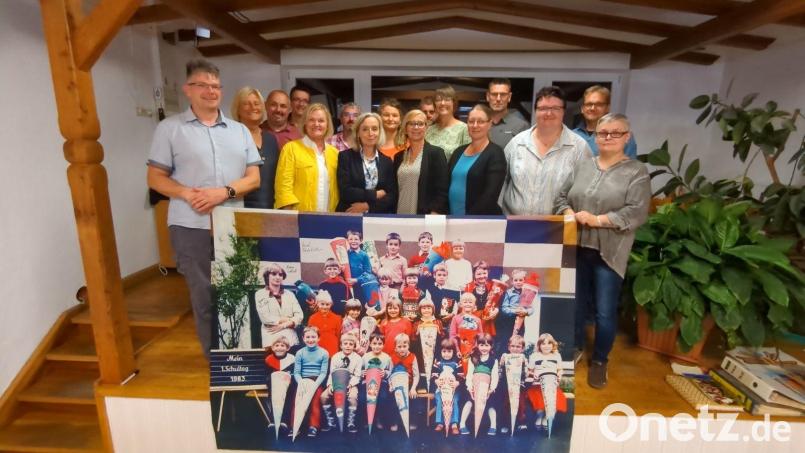 Damals und heute: Zum Treffen nach 40 Jahren hatten die Ehemaligen auch ein vergrößertes Foto, das an ihrem ersten Schultag entstanden ist, mitgebracht. Bild: Erna Worm/exb