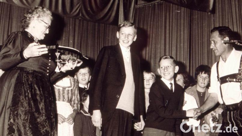 Mit den Liedern „He Michl“ und dem Schnodahüpfl „Dou hint san ma vira“ gewannen die „Hirschauer Boum“ Heiner Schuster (Mitte links) und Werner Schulz (Mitte rechts) am 13. Oktober 1963 den ersten Preis beim 3. Bayerischen Kinder- und Jugendsingen. Als Siegerpreis überreichte Annette Thoma (links) eine Zither. Außerdem gratulierte Radio- und Fernsehmoderator Wastl Fanderl (rechts). Archivbild: Sepp Strobl