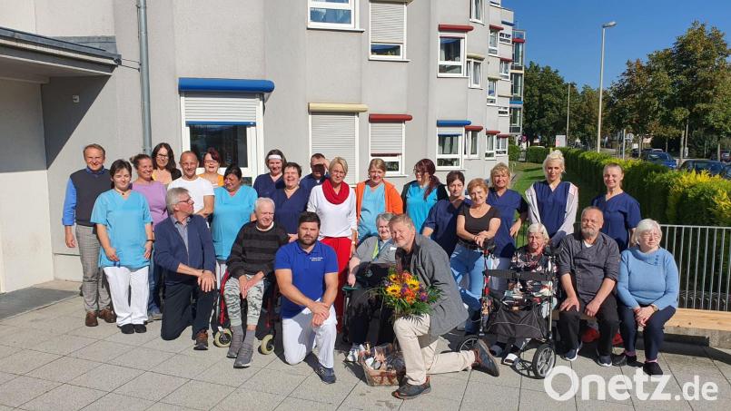 Hier verabschieden die Mitarbeiter der Diakonie ihren Diakon Wolfgang Reuther (knieend, mit Blumen). Neue Einrichtungsleiterin ist Sonja Rummler (rotes Halstuch). Als neuer Pflegedienstleiter wirkt Alexander Möstel (vorne, links, knieend). Bild: Diakonie/exb
