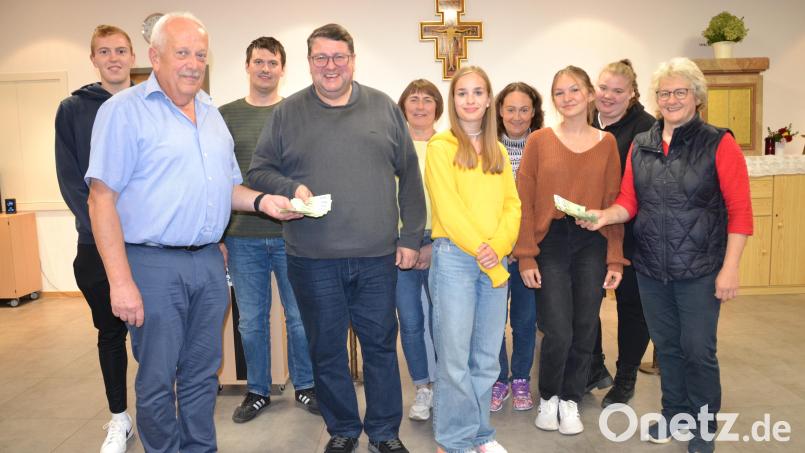 Die Pfarrgemeinderats-Sprecherin Elisabeth Völkl (rechts) und Pfarrgemeinderat Hermann Ach (links) überreichten zusammen mit dem Gremium eine Spende von 1.600 Euro aus dem Erlös des Pfarrfestes als Zuschuss für die Ministrantenwallfahrt (800 Euro) und für die Apostelleuchter der Pfarrkirche (800 Euro) an Pfarrer Udo Klösel. Bild: gi