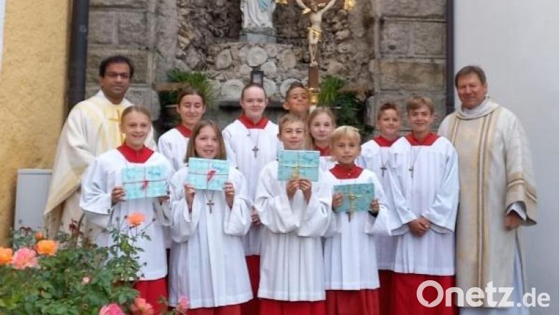 Pfarrer Pater Anish George (links) und Diakon Rudi Hoffmann (rechts) mit den neuen Ministranten nach dem Aufnahmegottesdienst an der Grotte auf dem Kirchplatz. Bild: soj/exb