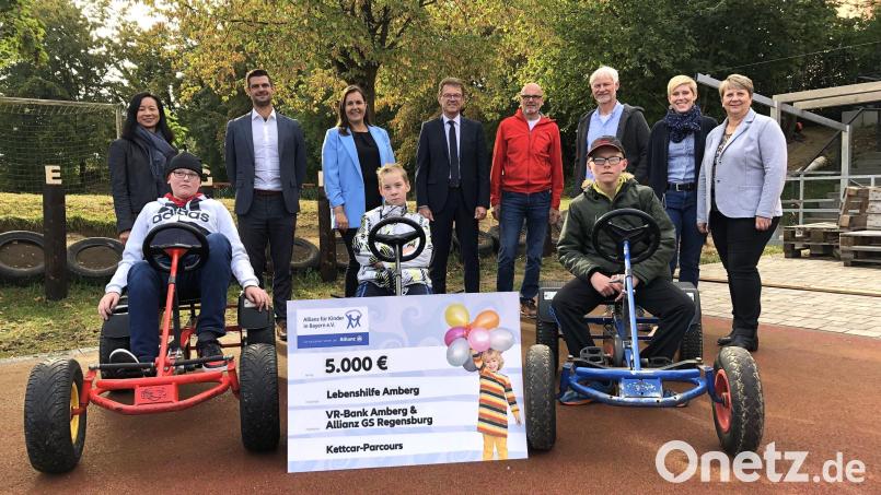 Voller Stolz präsentierten die Rupert-Egenberger-Schüler ihre neue Kettcar-Bahn. Zur Spendenübergabe waren gekommen: „Allianz für Kinder in Bayern“-Geschäftsführerin Châu Báu Tang-Rupp (links) sowie die lokalen Projektpaten. Sie überreichten den Scheck an Erlebnis- und Ergotherapeut Thomas Ertel (Vierter von rechts), der die Gäste gemeinsam mit Schulleiter Michael Schuierer (Dritter), Fachbereichsleiterin der Heilpädagogischen Tagesstätte, Juliana Schweitzer, Lebenshilfe-Geschäftsführerin Katrin Panek und den Schülern empfing. Bild:  Mariella Kramer/exb