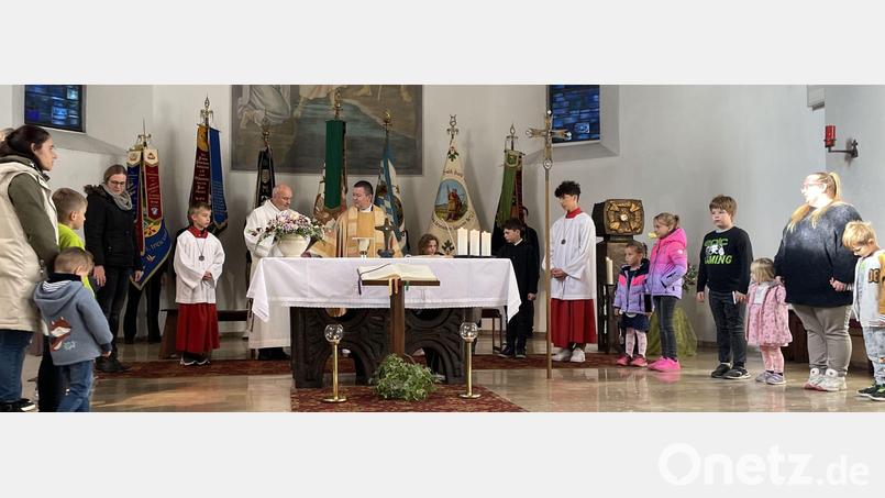 Pfarrer Ferdinand Weinberger (Mitte) feierte den Gottesdienst mit Unterstützung der Kindergartenkinder und Fahnenabordnungen der Vereine. Bild: gis