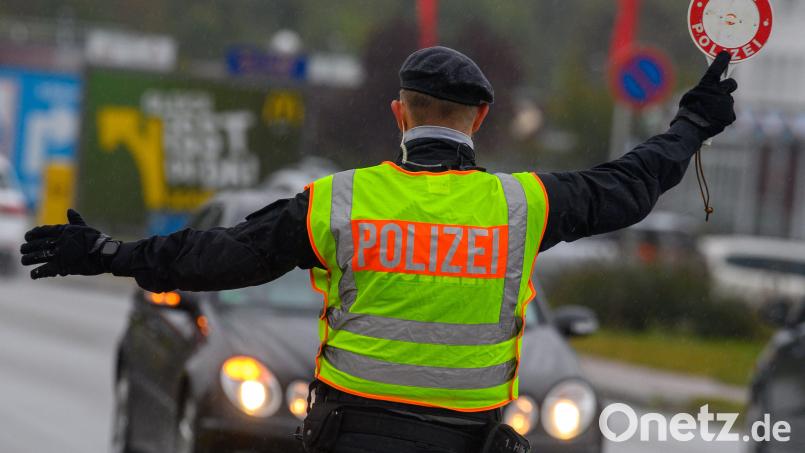 Ein Polizist winkt mit einer Polizeikelle einen Autofahrer aus dem Straßenverkehr. Symbolbild: Klaus-Dietmar Gabbert