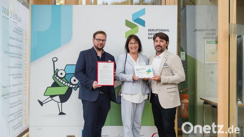 Die stellvertretenden Schulleiter Christian Reisinger (rechts) und Alexander Frey (links) nehmen zusammen mit der ehemaligen Schulleiterin Hannelore Reil-Heining die Auszeichnung entgegen. Bild: bbw/exb