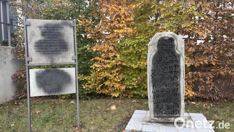 Der Tatort in Tegernheim bei Regensburg. Unbekannte haben den Grabstein und eine Erläuterungstafel mit schwarzer Farbe beschmiert. Bild: ehi