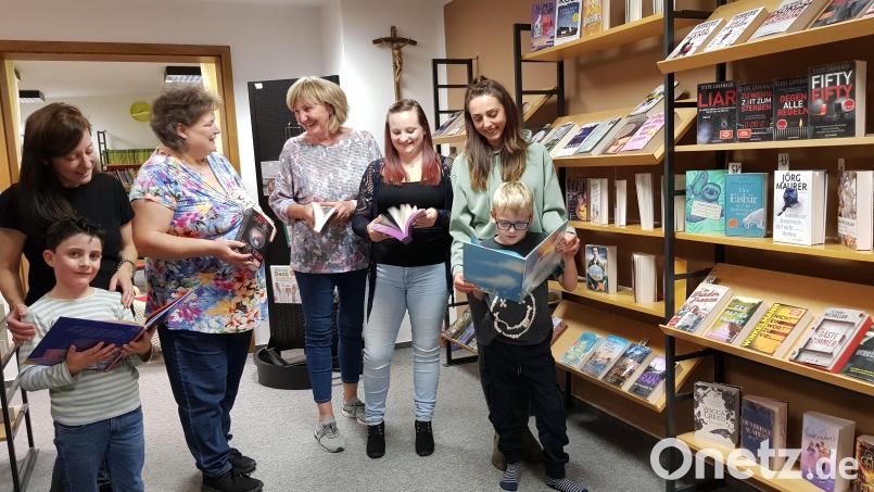 Auch die jüngsten Besucher der Gemeinde- und Pfarrbücherei Moosbach haben sichtlich Spaß beim abendlichen Stöbern durch die Bücherregale. Bild: gi