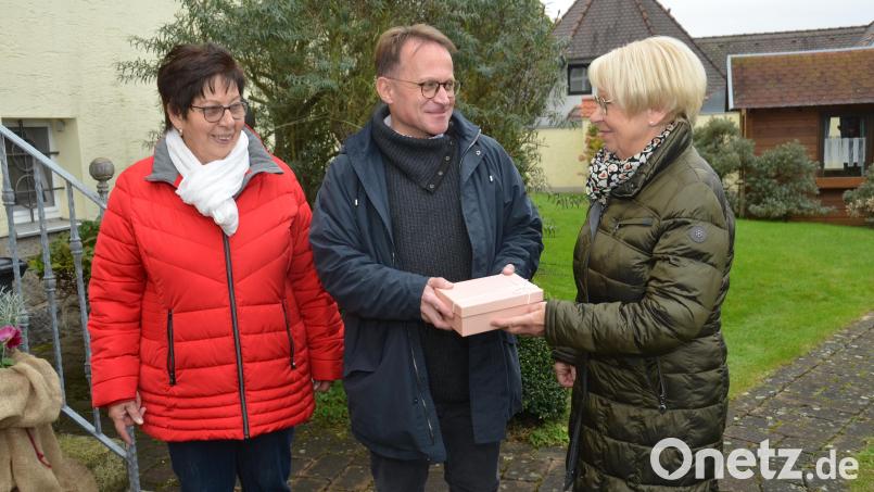 Martha Simacek (rechts) und Hilde Baierl (links) haben den Kräuterbuschen-Aktionstag initiiert und so mit ihrem Team 750 Euro für die Innenrenovierung der Katholischen Stadtpfarrkirche erlöst, die sie nun an Dekan Alexander Hösl für diesen Zweck übergaben. Bild: dob