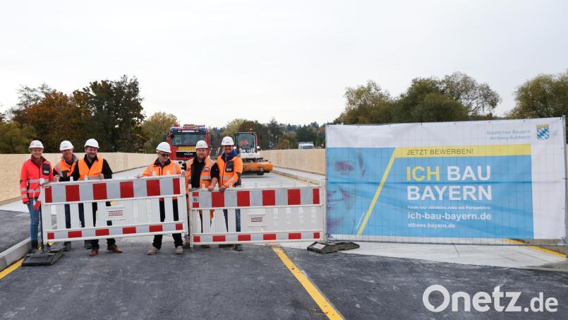 Bürgermeister Peter Neumeier, Bauoberrat Hannes Neudam (Mitte) geben mit Vertretern der bauausführenden Firma den Verkehr über die Behelfsbrücke frei. &quot;Die Brücke hält&quot; stellte die Besatzung des Löschfahrzeuges der Feuerwehr im HIntergrund fest, die als Erste die Notbrücke passierten. Bild: mab